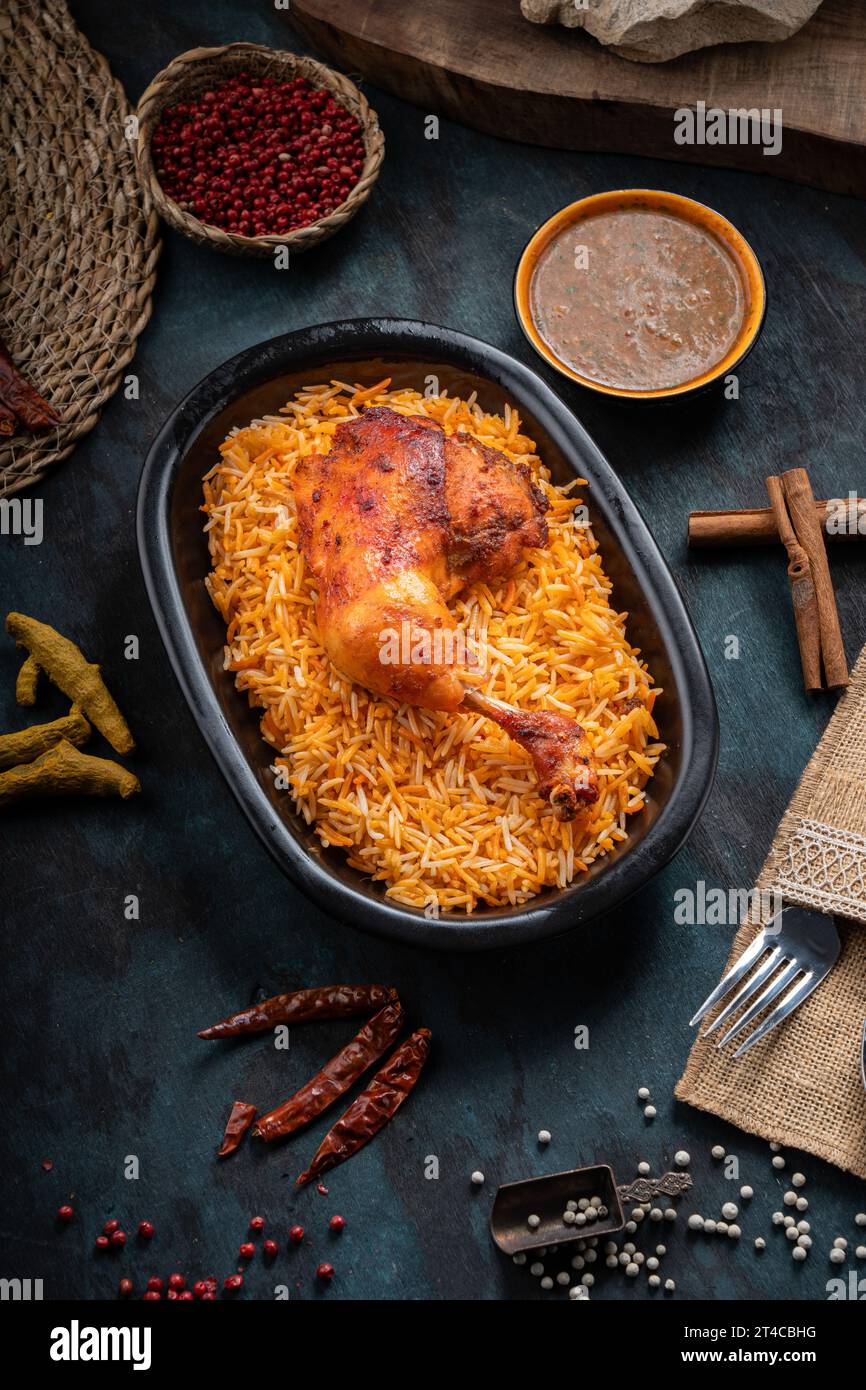 Plat de riz Mandi avec viande de poulet grillée et épices sur fond vert foncé Banque D'Images