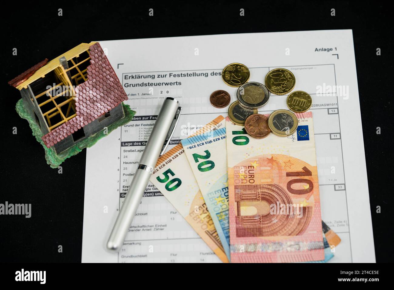 Document sur la taxe foncière avec stylo à bille, maison et euros Banque D'Images
