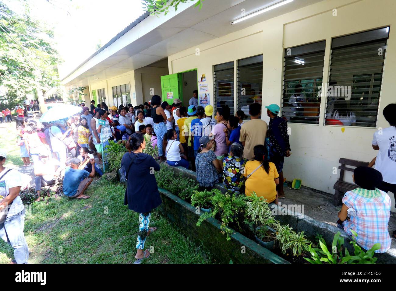 Quezon, Philippines. 30 octobre 2023. Les électeurs s'alignent à l'extérieur de l'enceinte de poling et attendent leur tour pour voter sur l'élection nationale de Brgy et l'élection de Sangguniang Kabataan à l'école élémentaire Rizal à Brgy. Rizal San Narciso, province de Quezon, le 30 octobre 2023. Chaque barangay a un chef de l'exécutif élu, le capitaine du barangay, et une législature de huit sièges, le Sangguniang Barangay (conseil de Sangguniang), dont sept sont élus au cours de cette élection. Banque D'Images