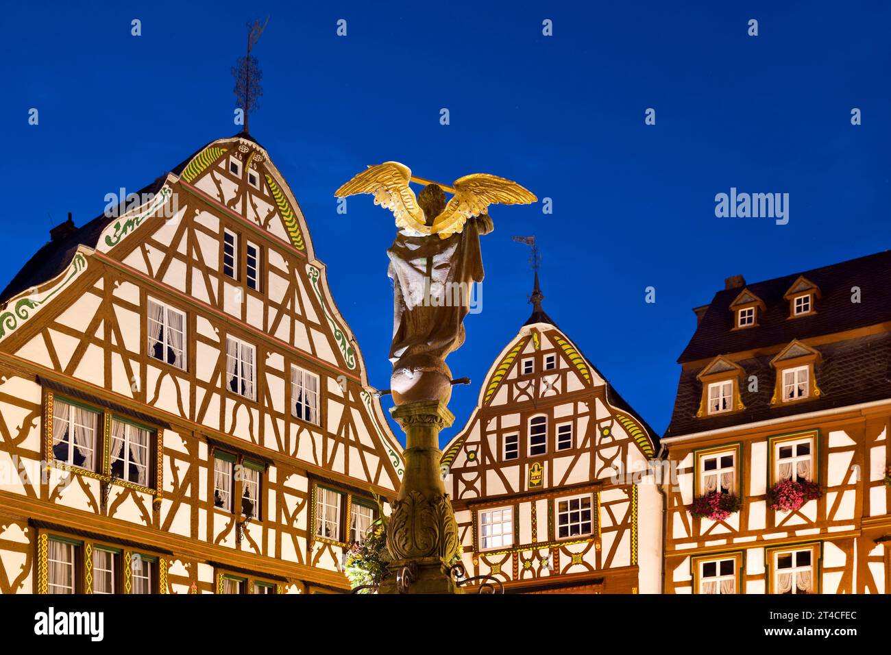 Maisons à colombages à pignons avec St. Fontaine de Michel sur la place du marché médiéval le soir, Allemagne, Rhénanie-Palatinat, Bernkastel-Kues Banque D'Images