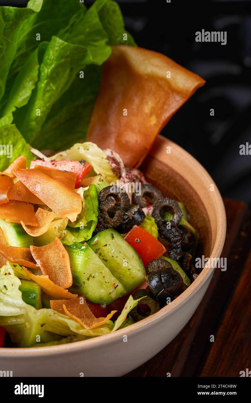 Gros plan d'une assiette de salade de fattoush syrienne avec des olives et du pain grillé Banque D'Images