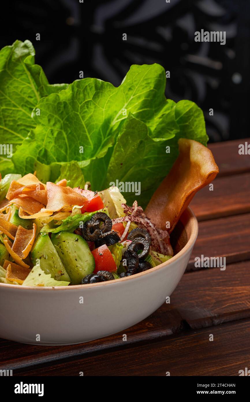 Gros plan d'une assiette de salade de fattoush syrienne avec des olives et du pain grillé Banque D'Images