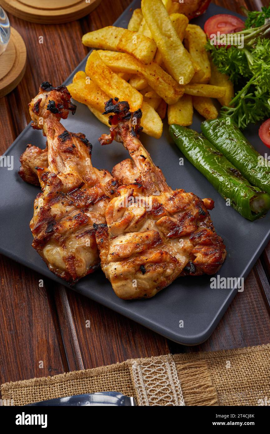 Gros plan d'une assiette de cuisses de poulet grillées avec purée de pommes de terre et romarin Banque D'Images