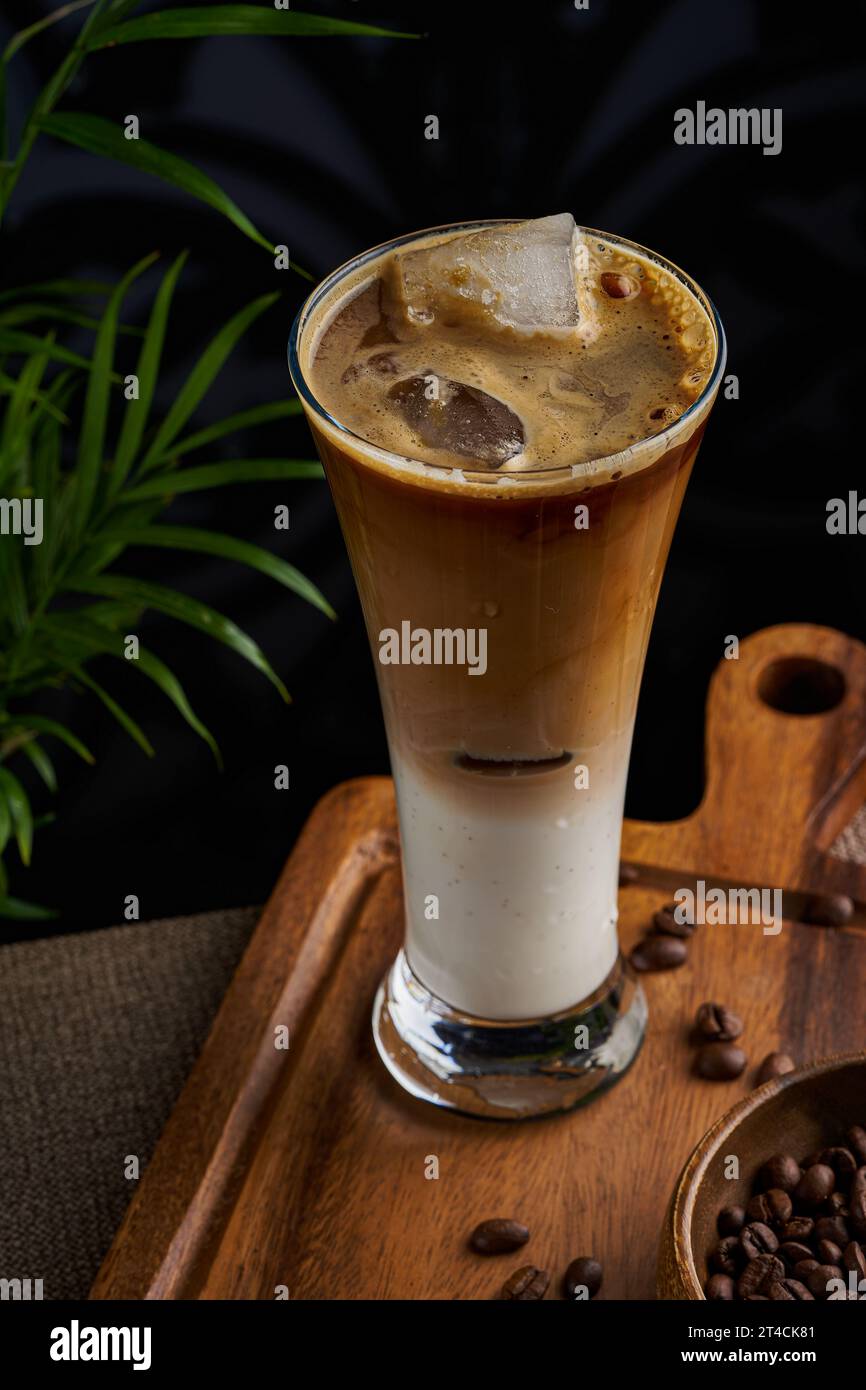 Une tasse de café froid sur un fond sombre et plancher en bois Banque D'Images