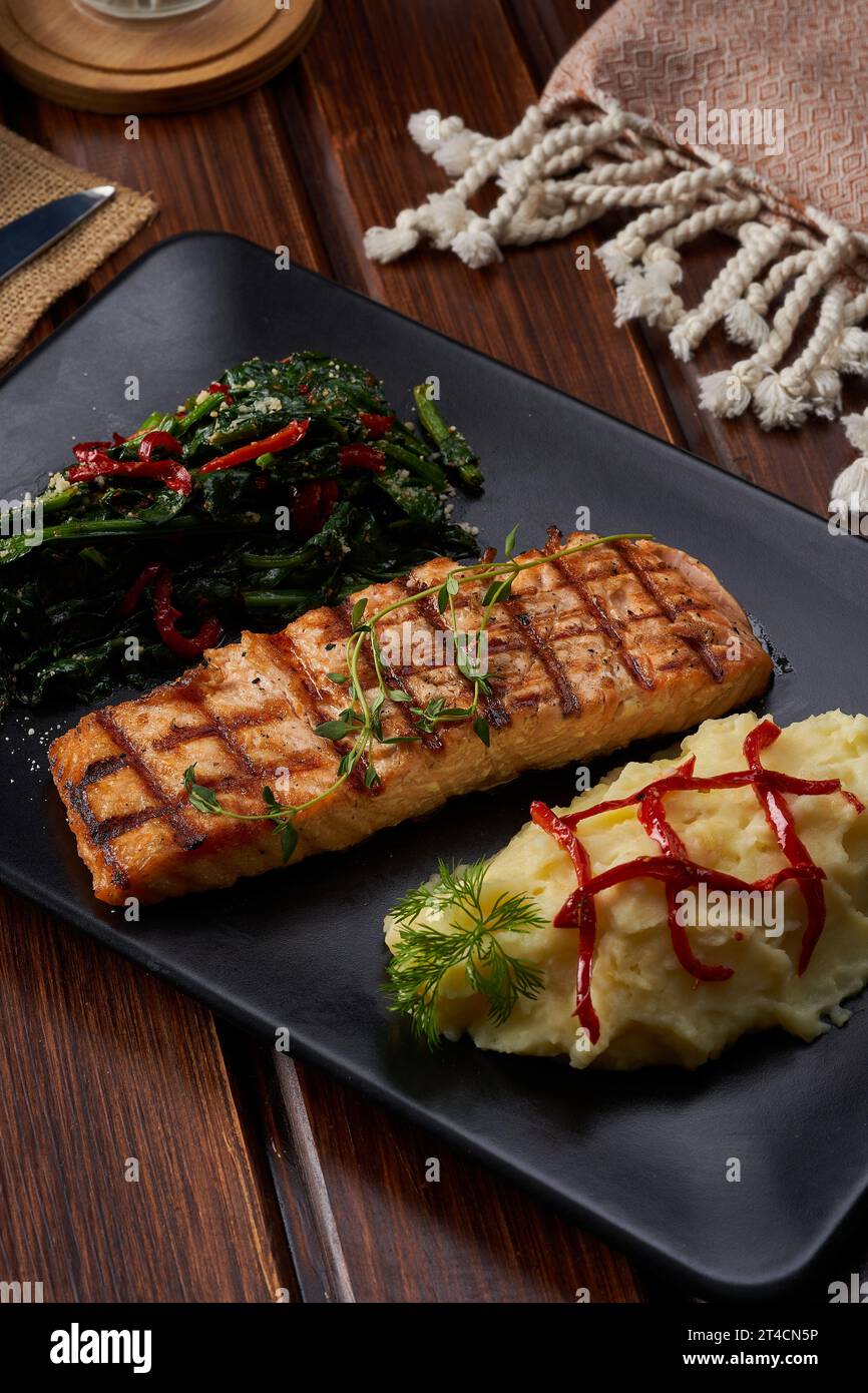 Une macro shoot d'une assiette de saumon avec des légumes bouillis sur un plancher en bois Banque D'Images