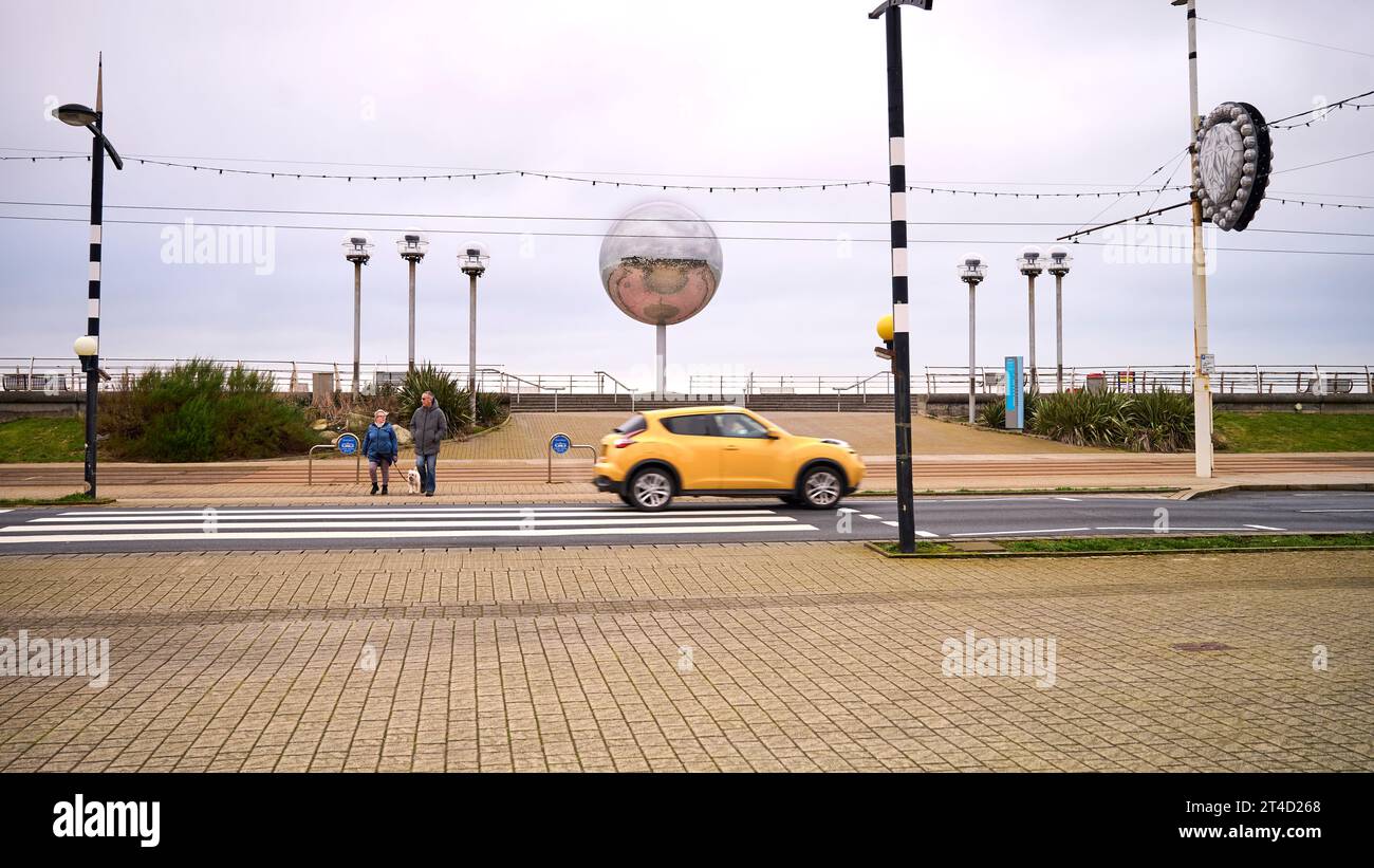 Les gens attendent de traverser la route au croisement de Zebra devant le ballon miroir Blackpool Banque D'Images