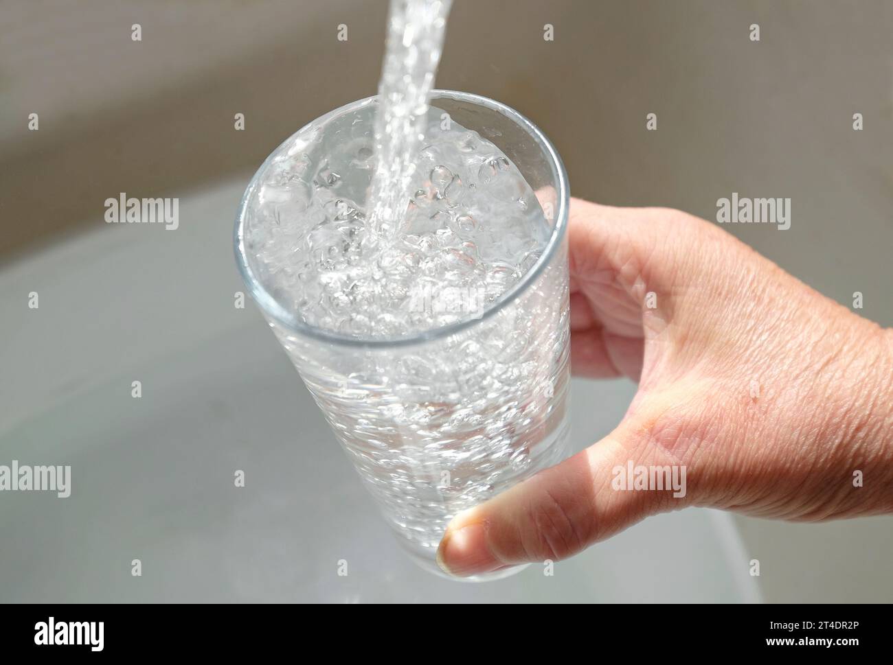 remplissage du verre avec de l'eau du robinet Banque D'Images
