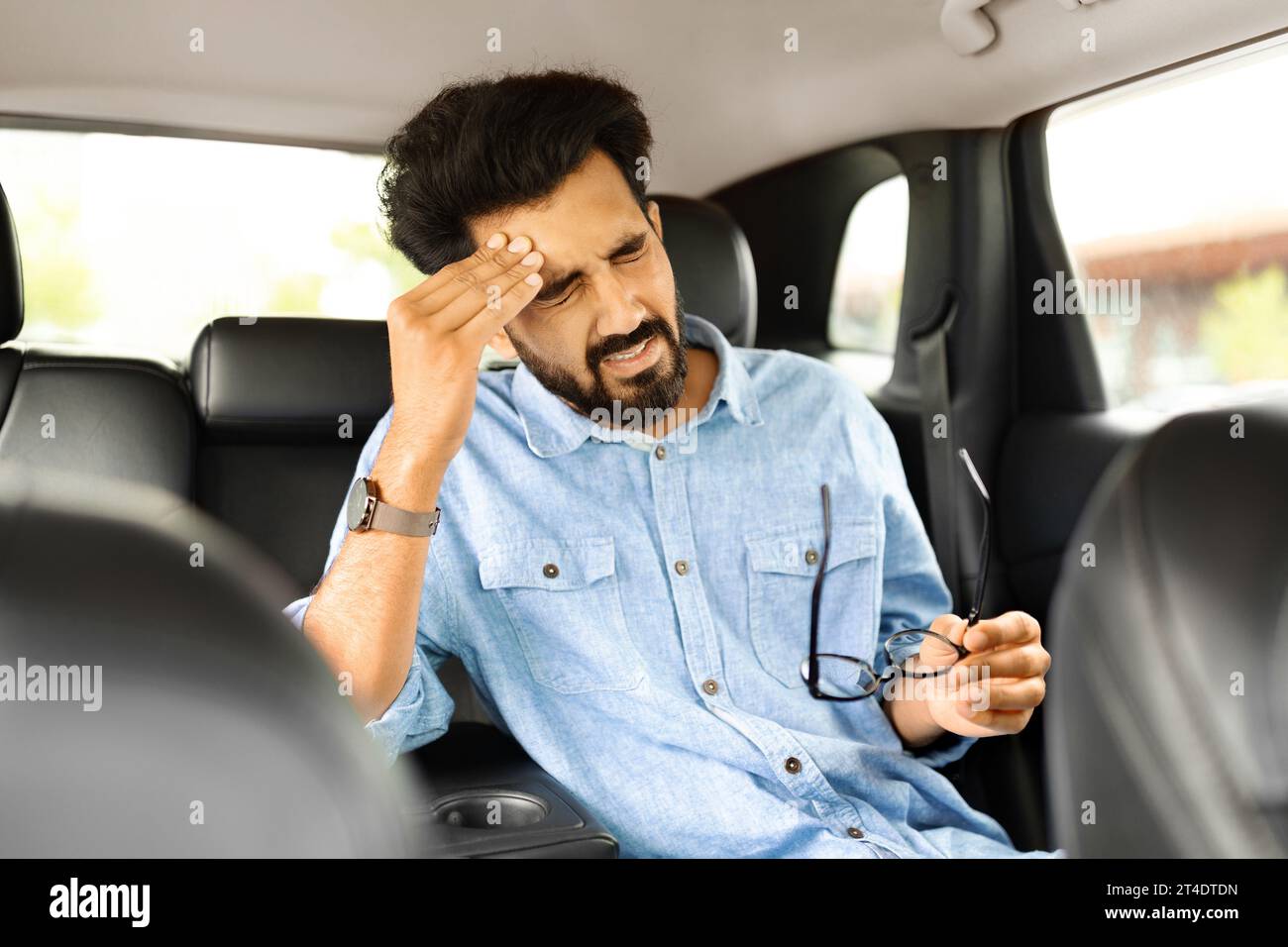 Épuisé, homme surchargé fermant les yeux avec la main, éprouvant des maux de tête Banque D'Images