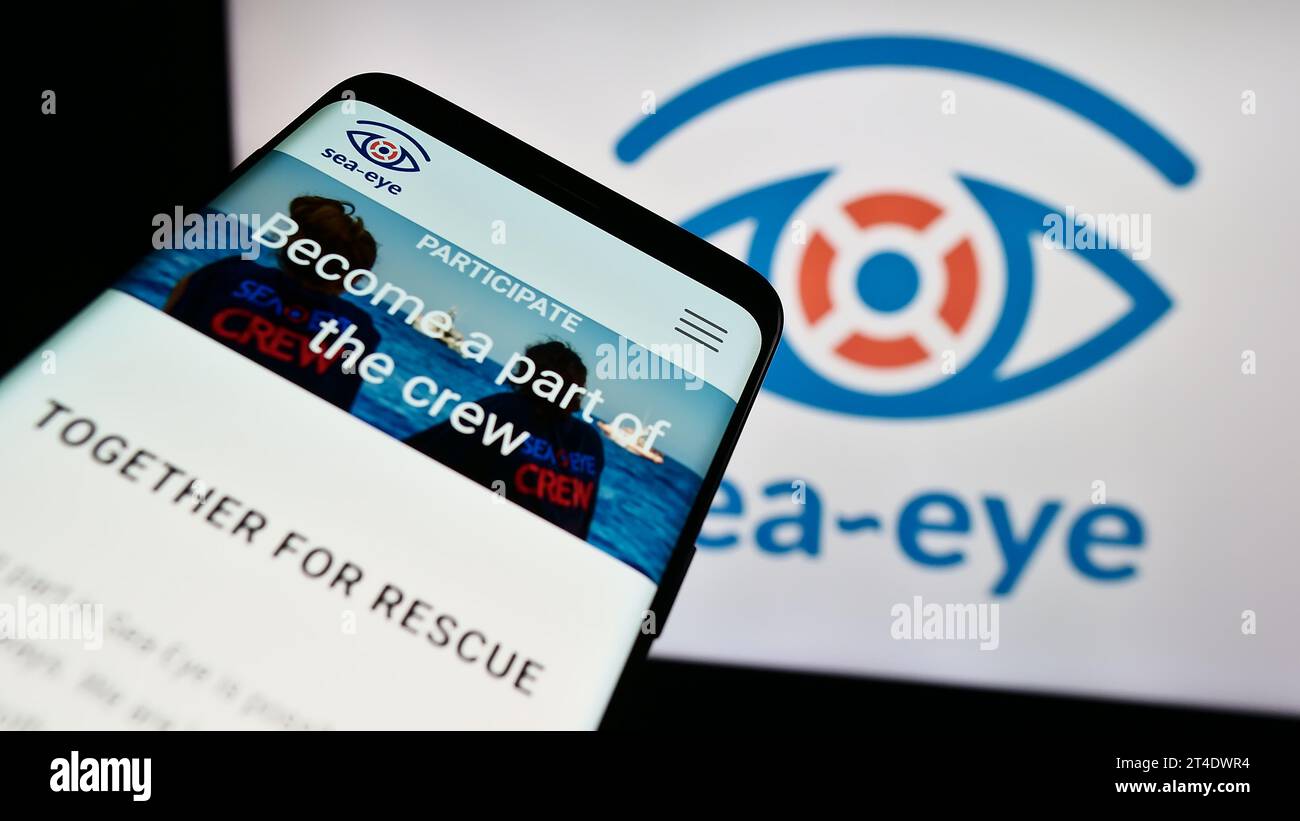Téléphone portable avec le site web de l'association allemande de sauvetage en mer Sea-Eye e.V. devant le logo. Effectuez le focus sur le coin supérieur gauche de l'écran du téléphone. Banque D'Images