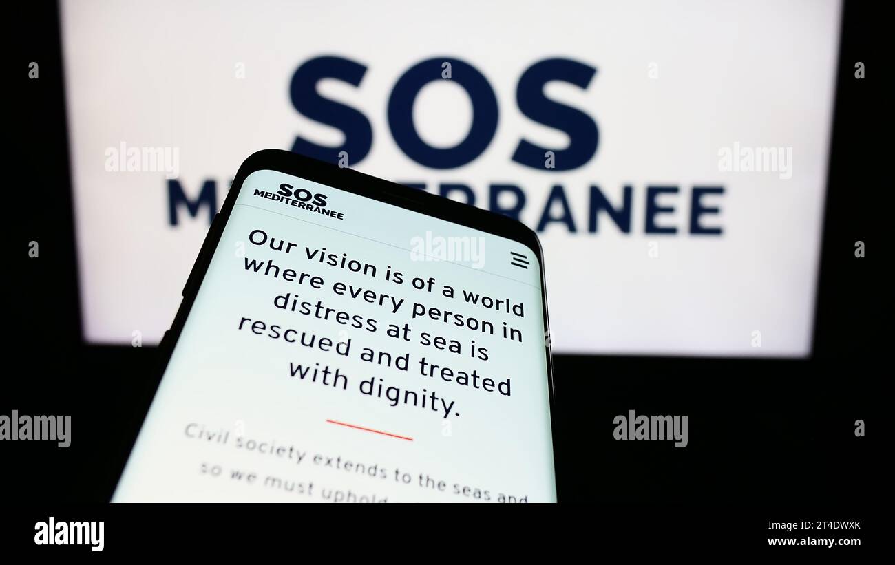 Smartphone avec le site de l'organisation française de sauvetage en mer SOS Mediterranee devant le logo. Effectuez le focus sur le coin supérieur gauche de l'écran du téléphone. Banque D'Images