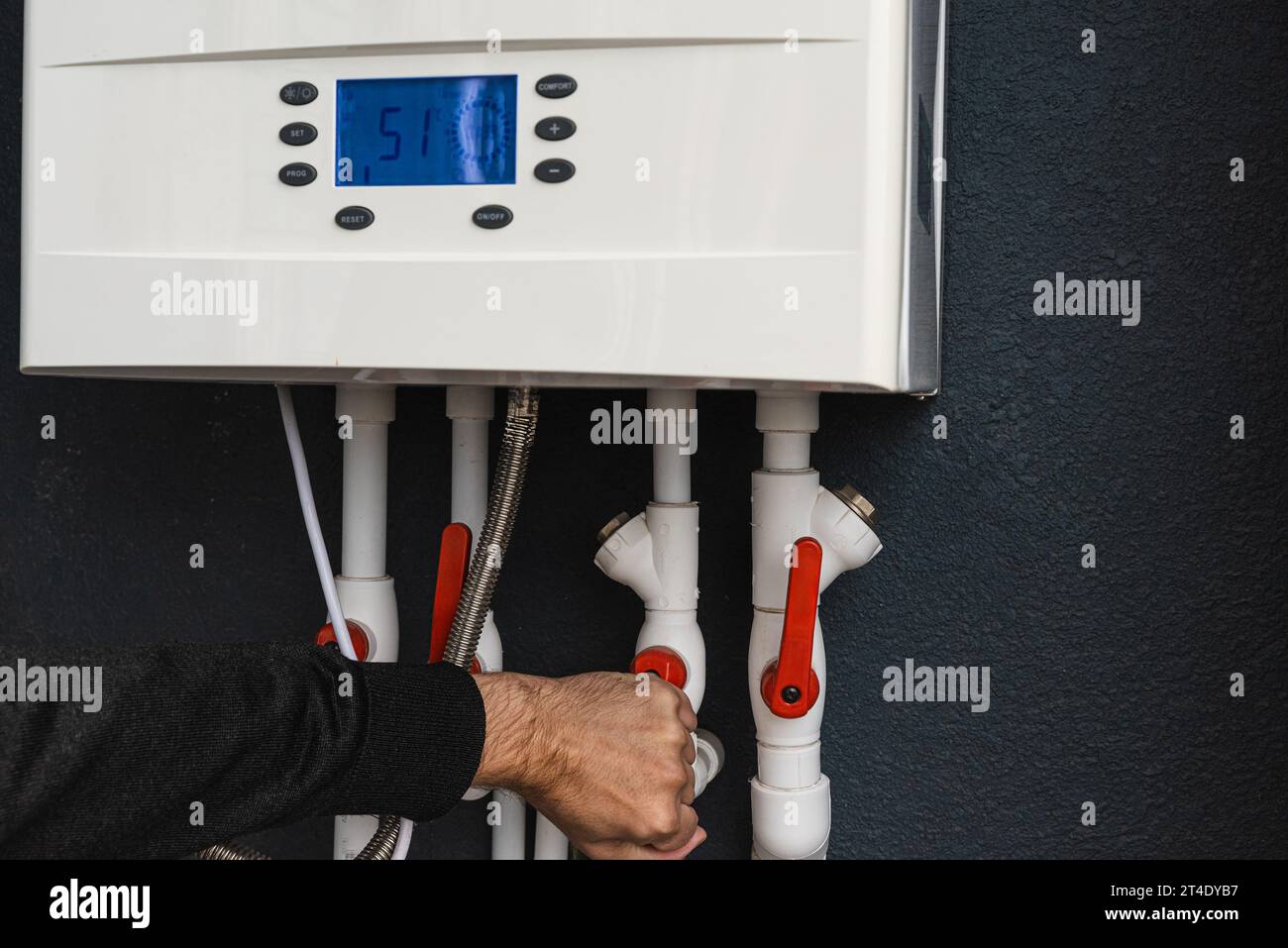 Main d'œuvre télécommande ou installation d'une chaudière à gaz à double circuit pour le chauffage à la maison et le chauffage à l'eau en hiver. Concept d'économie d'énergie et d'économie de chaleur Banque D'Images