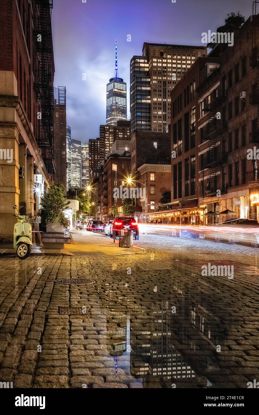 World Trade Center NYC - Cobblestone Street avec vue sur un World Trade Center communément connu sous le nom de Freedom Tower après une lourde douche du soir. Banque D'Images