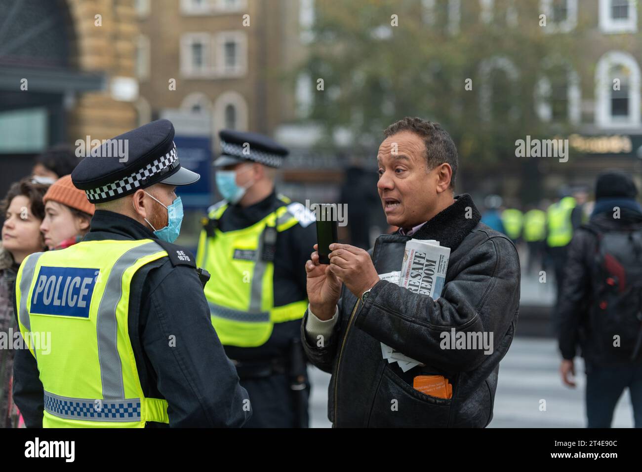 Personne filmant un officier de police lors d'une marche de protestation anti-confinement contre le coronavirus COVID 19 à Londres, Royaume-Uni. Enregistrement vidéo pour téléphone portable Banque D'Images