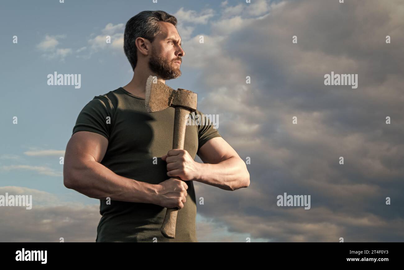 homme fort avec hache. homme caucasien tenir ax. homme brutal sur fond de ciel. copier l'espace Banque D'Images