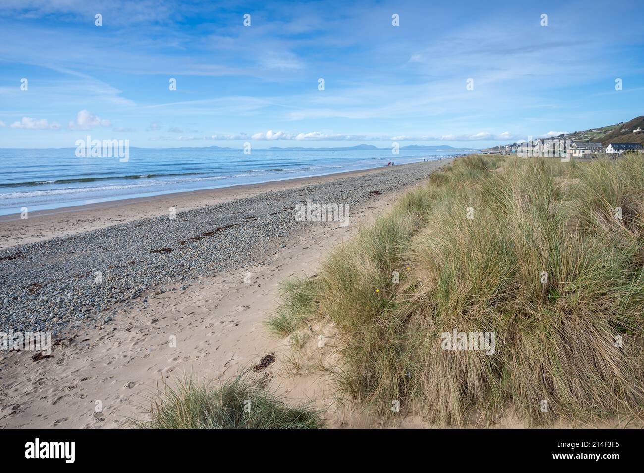 Une image HDR des cailloux et du sable sur la plage de Barmouth, soutenue par l'herbe des dunes. Banque D'Images