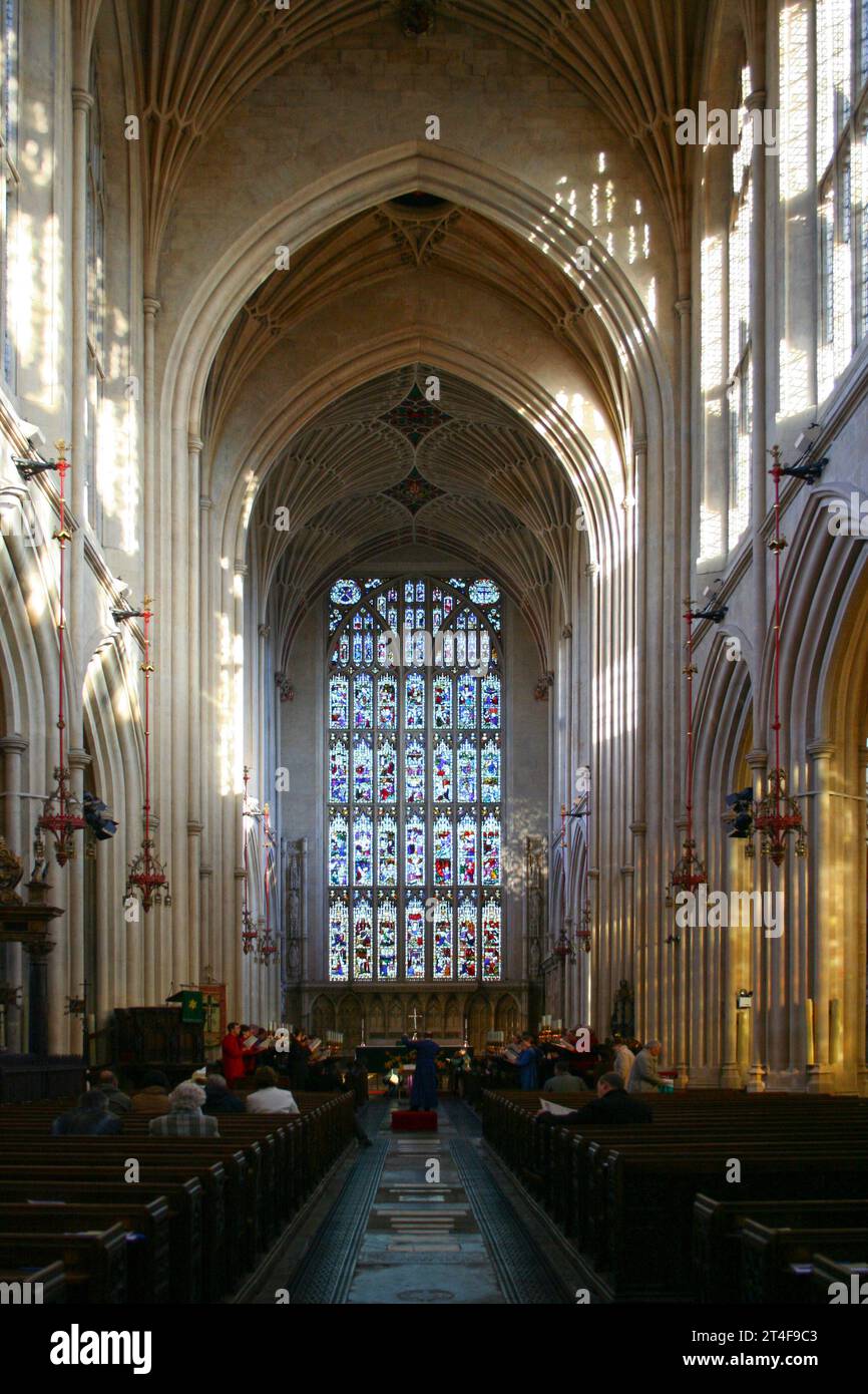 Bath, Angleterre - février 03 2007 : le vitrail et l'autel à l'extrémité orientale de la nef de l'abbaye de Bath lors d'une messe. Banque D'Images