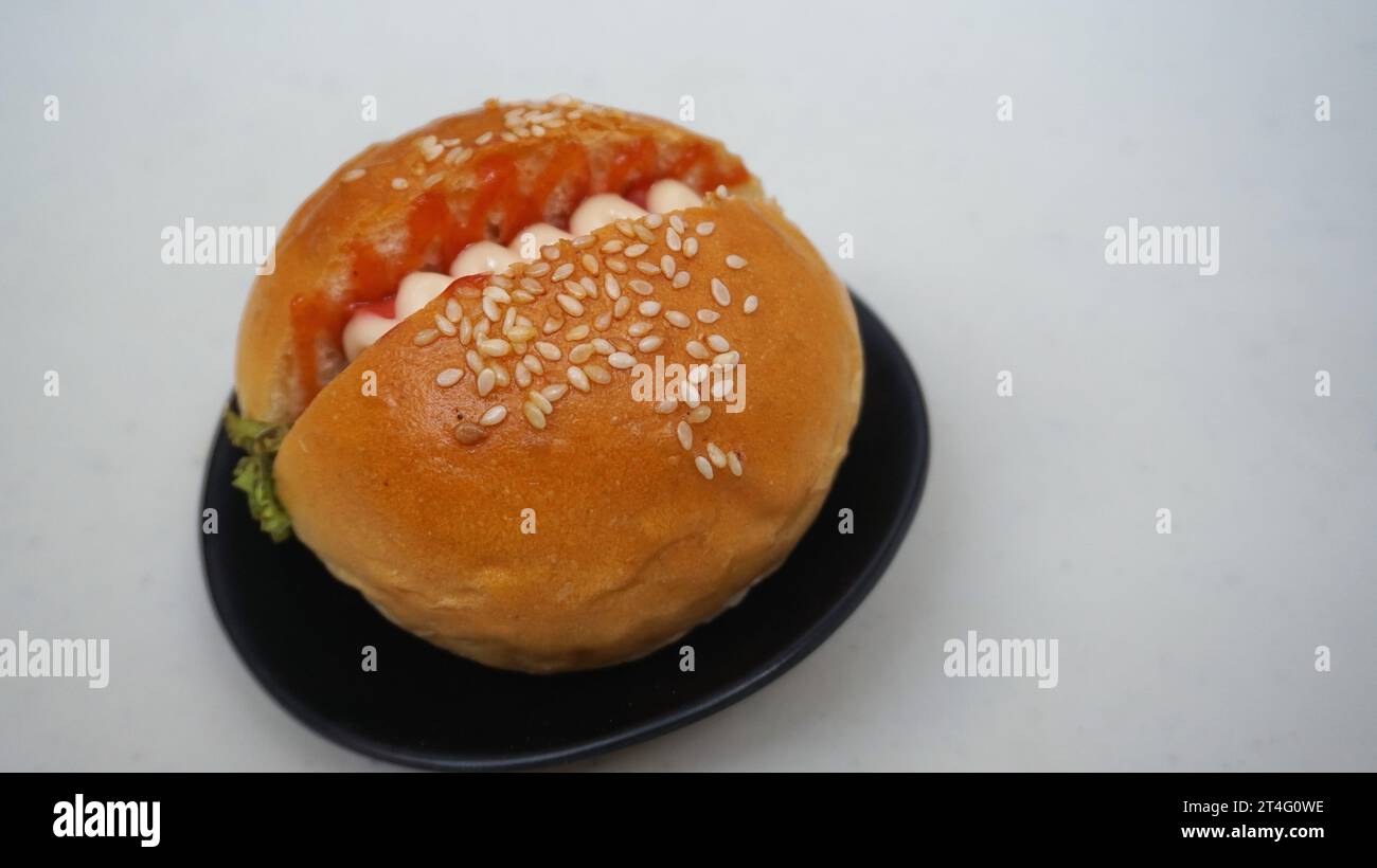 nourriture malsaine, restauration rapide, un hamburger est un pain rempli de viande, légumes, oignon et garni de mayonnaise et sauce chili Banque D'Images