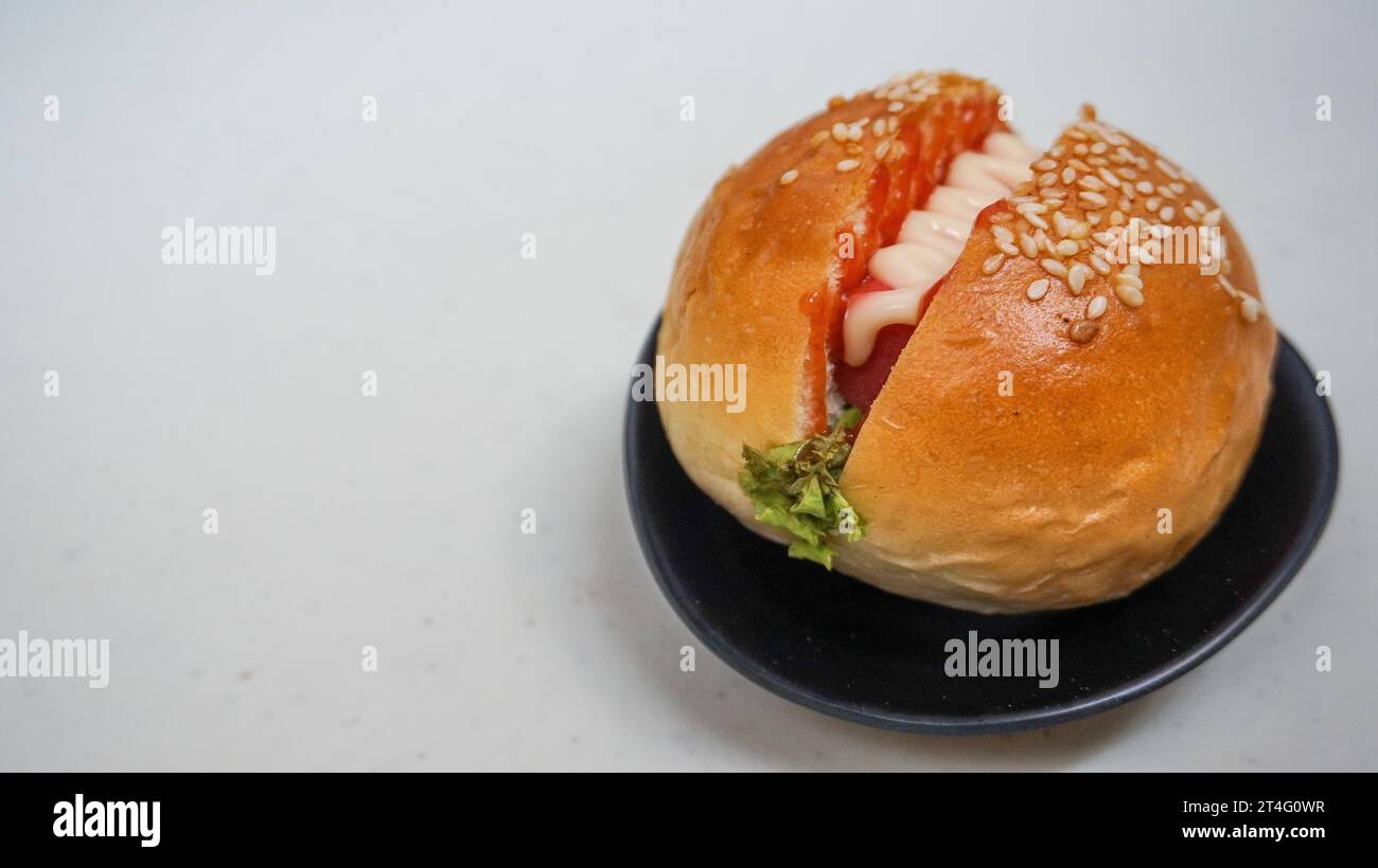 nourriture malsaine, restauration rapide, un hamburger est un pain rempli de viande, légumes, oignon et garni de mayonnaise et sauce chili Banque D'Images