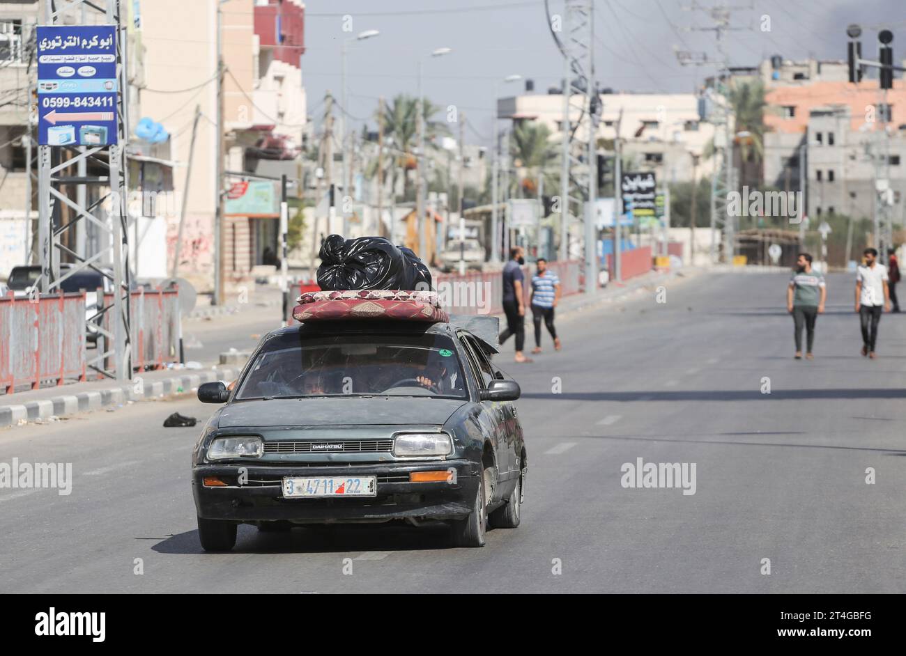 Gaza, Palestine. 30 octobre 2023. Les Palestiniens conduisent une voiture chargée d’effets personnels tandis que de la fumée coule en arrière-plan alors qu’ils fuient le camp de réfugiés de Nuseirat, dans le centre de la bande de Gaza, au milieu des combats en cours entre Israël et le groupe palestinien Hamas. Des milliers de civils, Palestiniens et Israéliens, sont morts depuis le 7 octobre 2023, après que des militants palestiniens du Hamas basés dans la bande de Gaza sont entrés dans le sud d’Israël dans une attaque sans précédent déclenchant une guerre déclarée par Israël au Hamas avec des bombardements de représailles sur Gaza. Crédit : SOPA Images Limited/Alamy Live News Banque D'Images