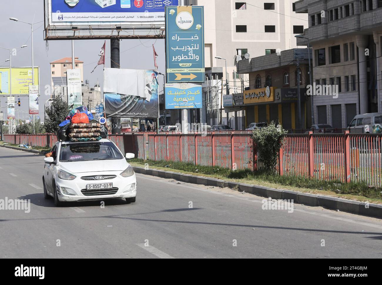 Les Palestiniens conduisent une voiture chargée d’effets personnels tandis que de la fumée coule en arrière-plan alors qu’ils fuient le camp de réfugiés de Nuseirat, dans le centre de la bande de Gaza, au milieu des combats en cours entre Israël et le groupe palestinien Hamas. Des milliers de civils, Palestiniens et Israéliens, sont morts depuis le 7 octobre 2023, après que des militants palestiniens du Hamas basés dans la bande de Gaza sont entrés dans le sud d’Israël dans une attaque sans précédent déclenchant une guerre déclarée par Israël au Hamas avec des bombardements de représailles sur Gaza. (Photo Ahmed Zakot/SOPA Images/Sipa USA) Banque D'Images