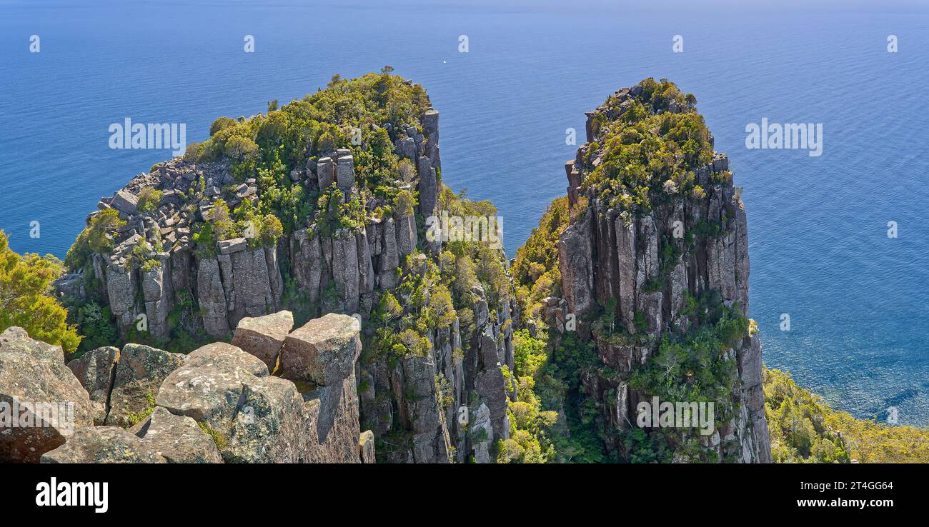 Bishop et Clerk, deux sommets de roche dolérite vue d'en haut avec un océan bleu calme derrière eux sur le parc national de Maria Island, Tasmanie, Australie Banque D'Images