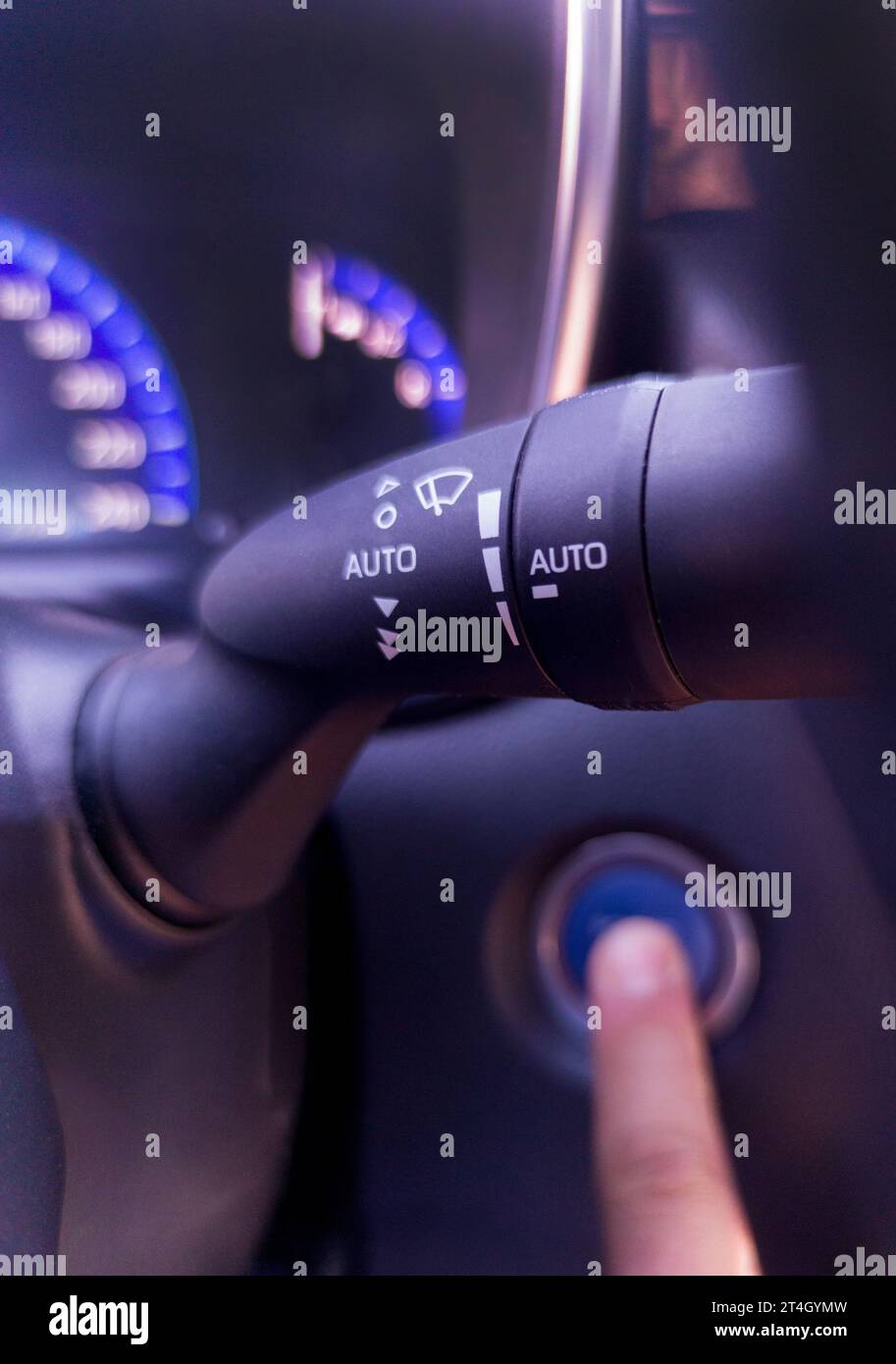 Le levier d'essuie-glace est mis au point pendant qu'un doigt appuie sur le bouton de démarrage Banque D'Images Le levier d'essuie-glace est mis au point pendant qu'un doigt appuie sur le bouton de démarrage Banque D'Images