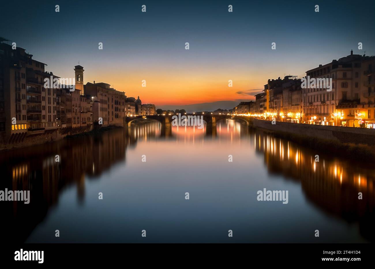 Belle vue sur le Ponte alla Carraia avec les couleurs chaudes du coucher de soleil reflété sur la rivière Arno. Vue relaxante et paisible Banque D'Images