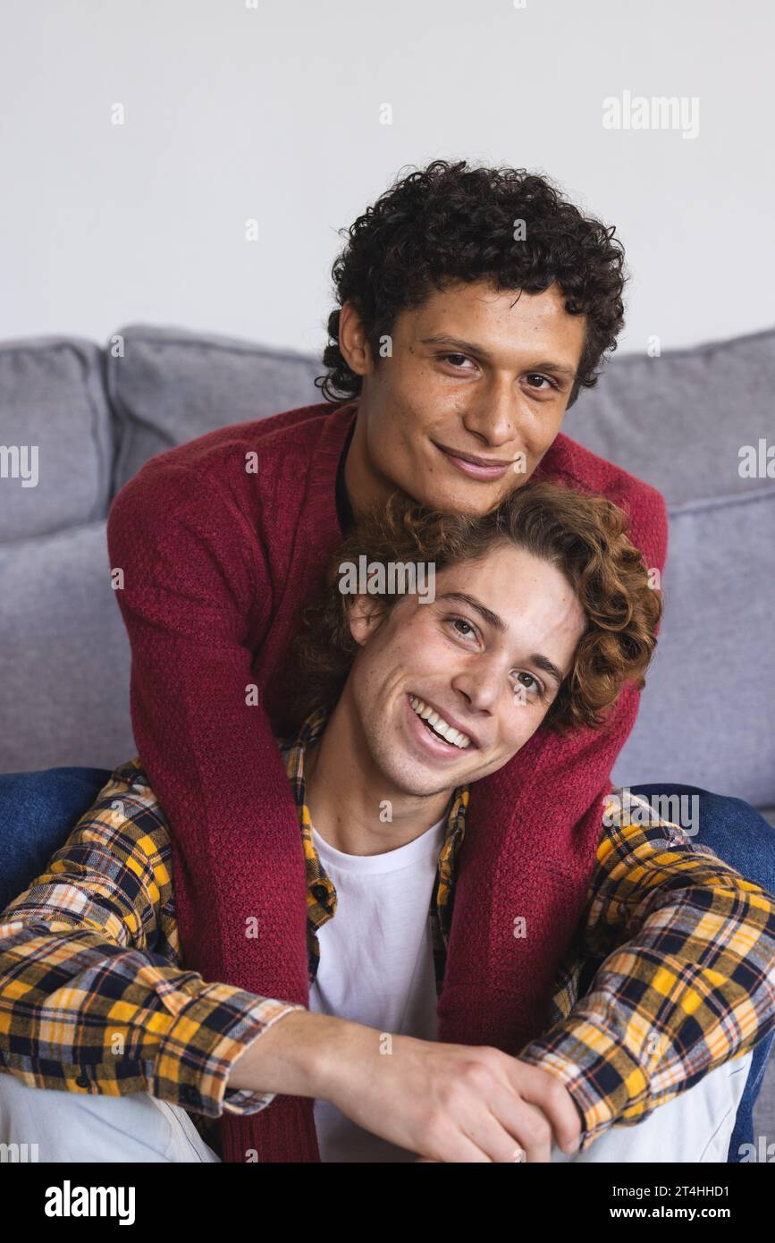 Portrait d'heureux couple masculin gay diversifié embrassant à la maison Banque D'Images