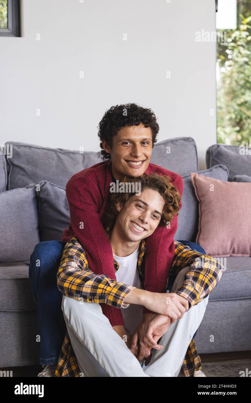 Portrait d'heureux couple masculin gay diversifié embrassant à la maison Banque D'Images