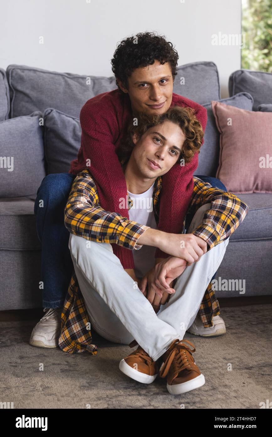Portrait d'heureux couple masculin gay diversifié embrassant à la maison Banque D'Images