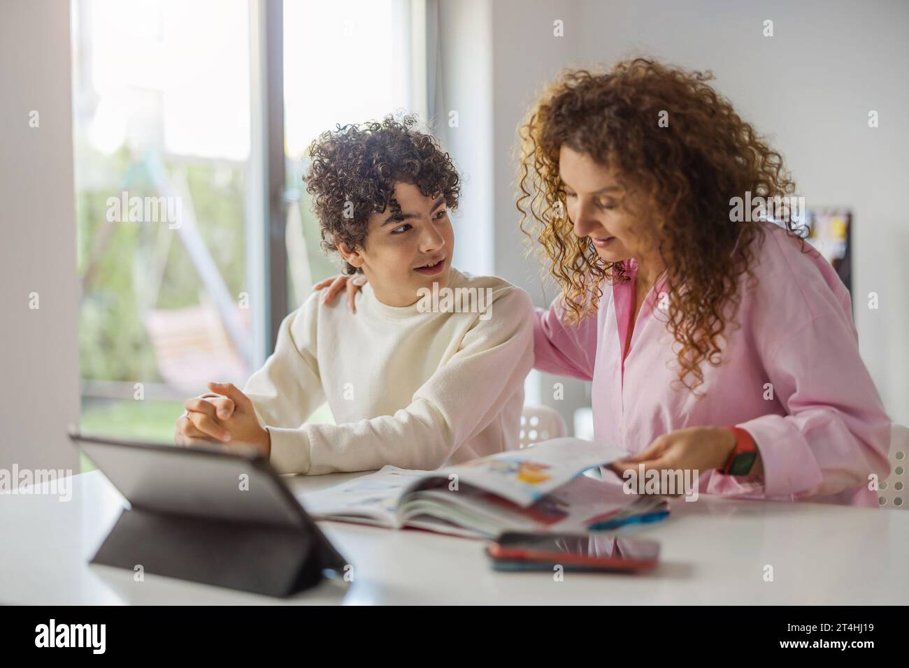 Mère aidant son fils à faire ses devoirs à la maison Banque D'Images
