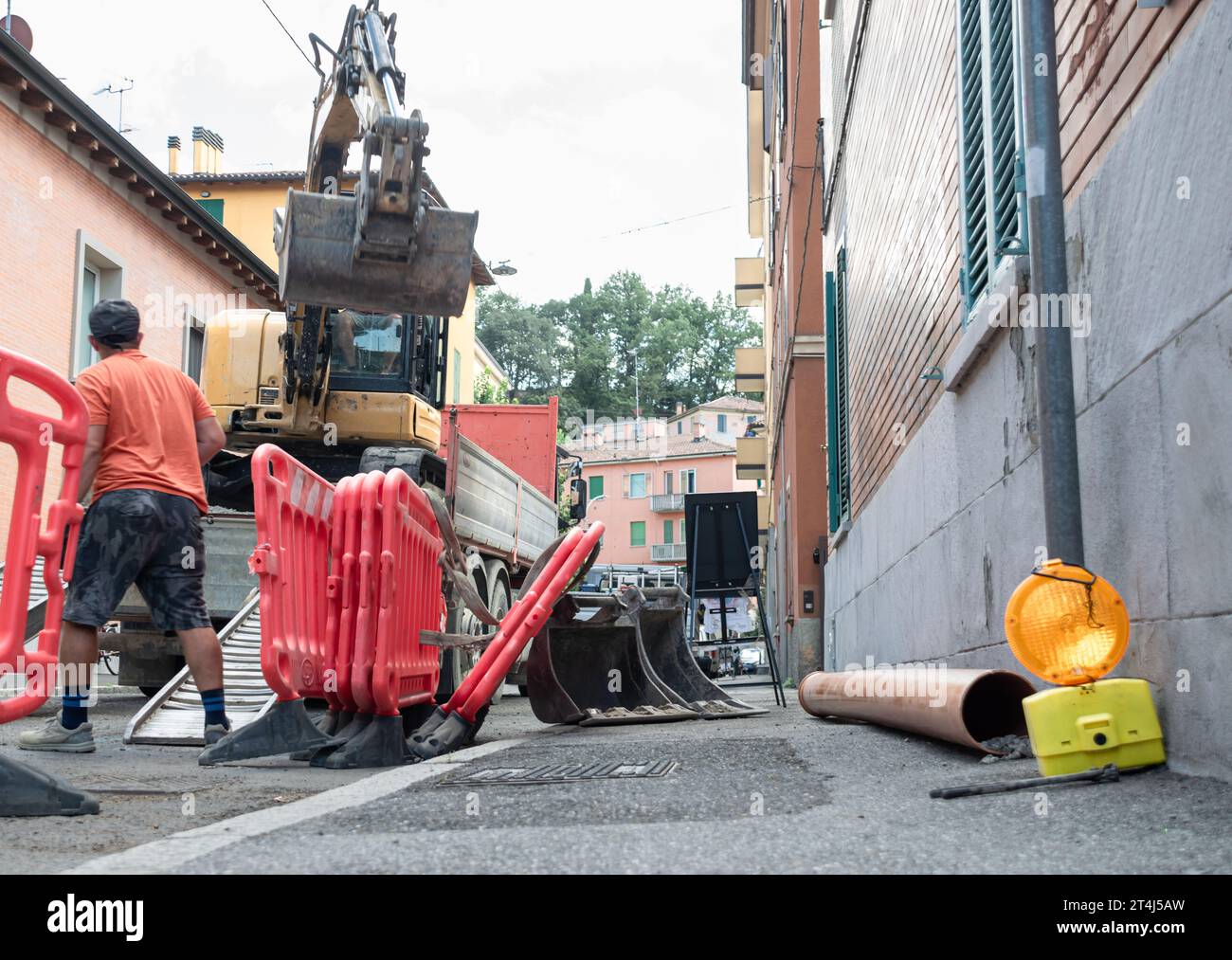 Zone de construction avec les opérateurs déployant la barrière, la pelle et le terrain de travail Banque D'Images