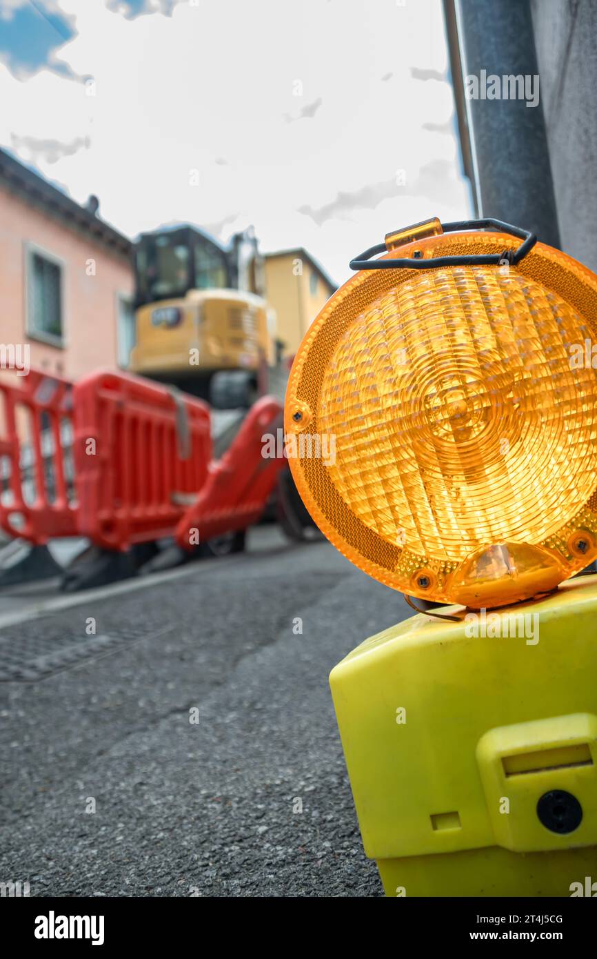 Lanterne de sécurité sur les travaux de construction avec barrières rouges et fond de pelle Banque D'Images