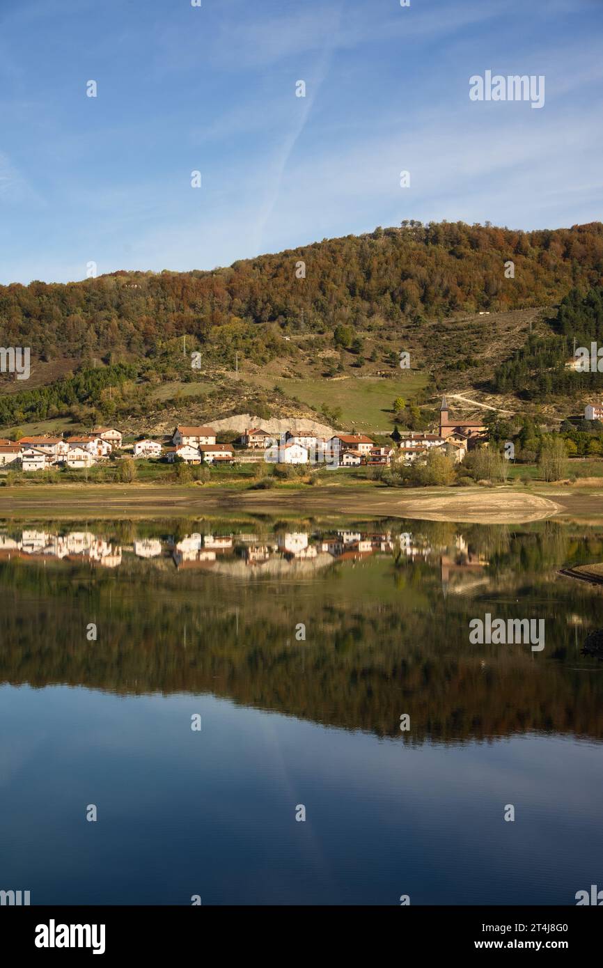 paysage automnal dyllique avec un beau lac et un village reflété dans les eaux propres et tranquilles par une journée ensoleillée. Idéal pour les projets liés à Banque D'Images