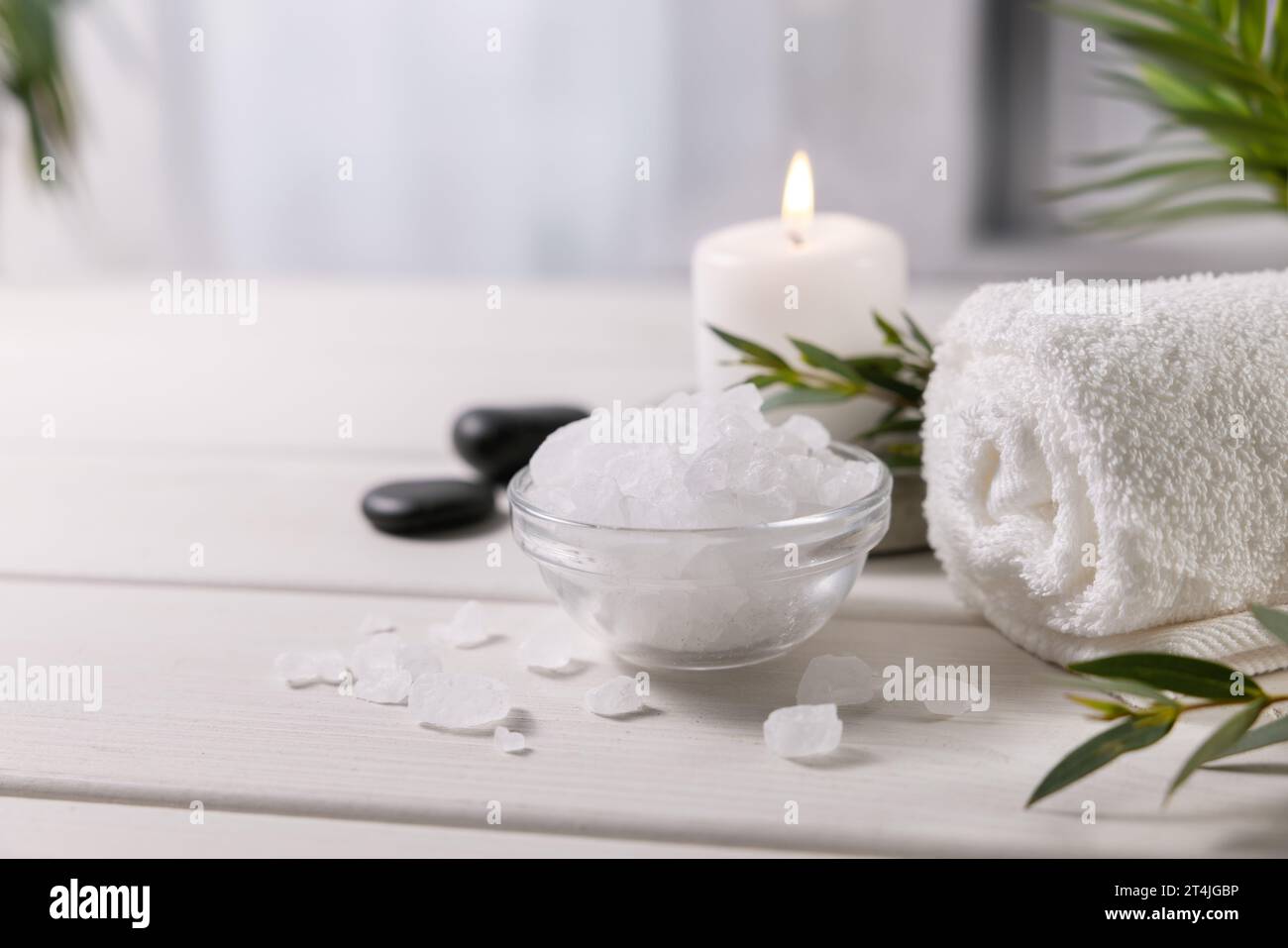composition avec sel de mer, serviette et bougie sur table en bois blanc au centre spa. espace de copie Banque D'Images