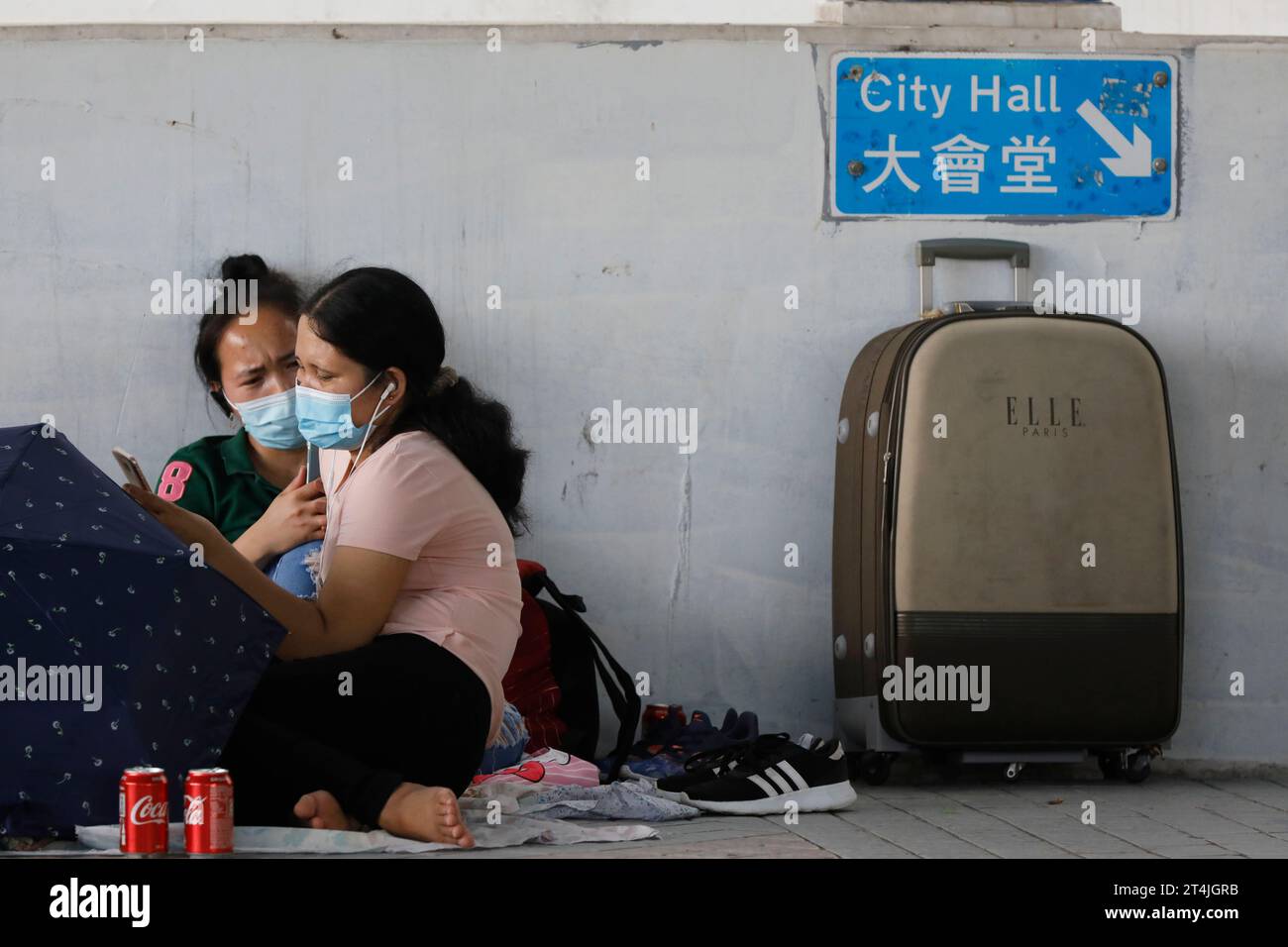 Deux travailleuses étrangères à l'étranger (OFW) portant des masques faciaux dans le quartier des affaires de Hong Kong Central pendant une journée de congé pendant la pandémie de Covid19 Banque D'Images