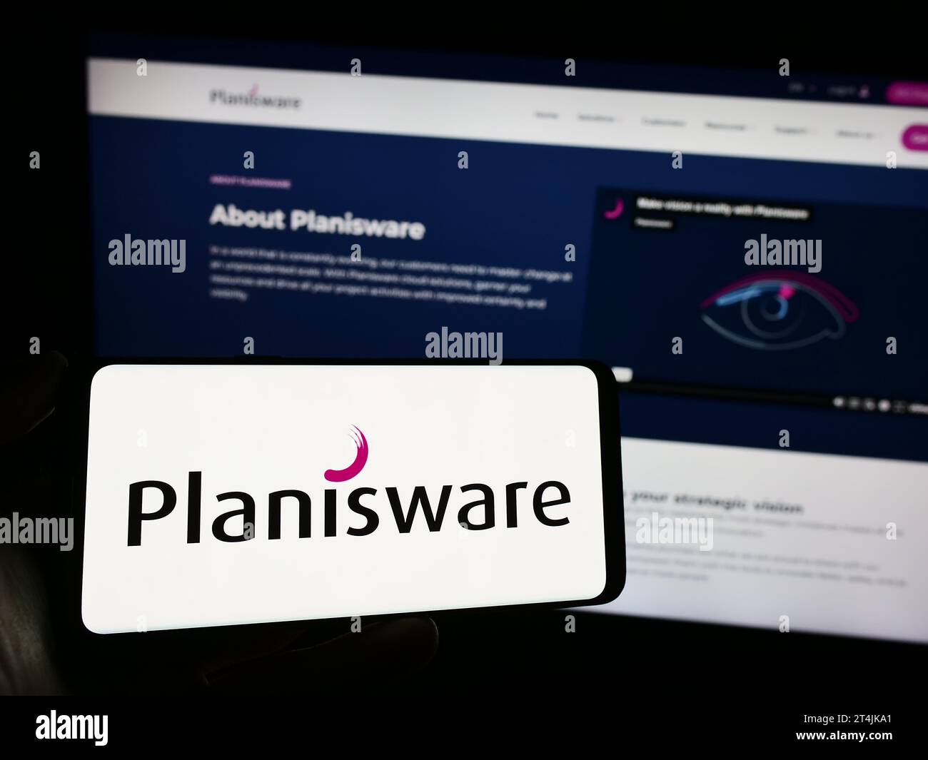 Personne détenant un téléphone portable avec le logo de la société française de logiciels Planisware SAS devant la page Web de l'entreprise. Concentrez-vous sur l'affichage du téléphone. Banque D'Images
