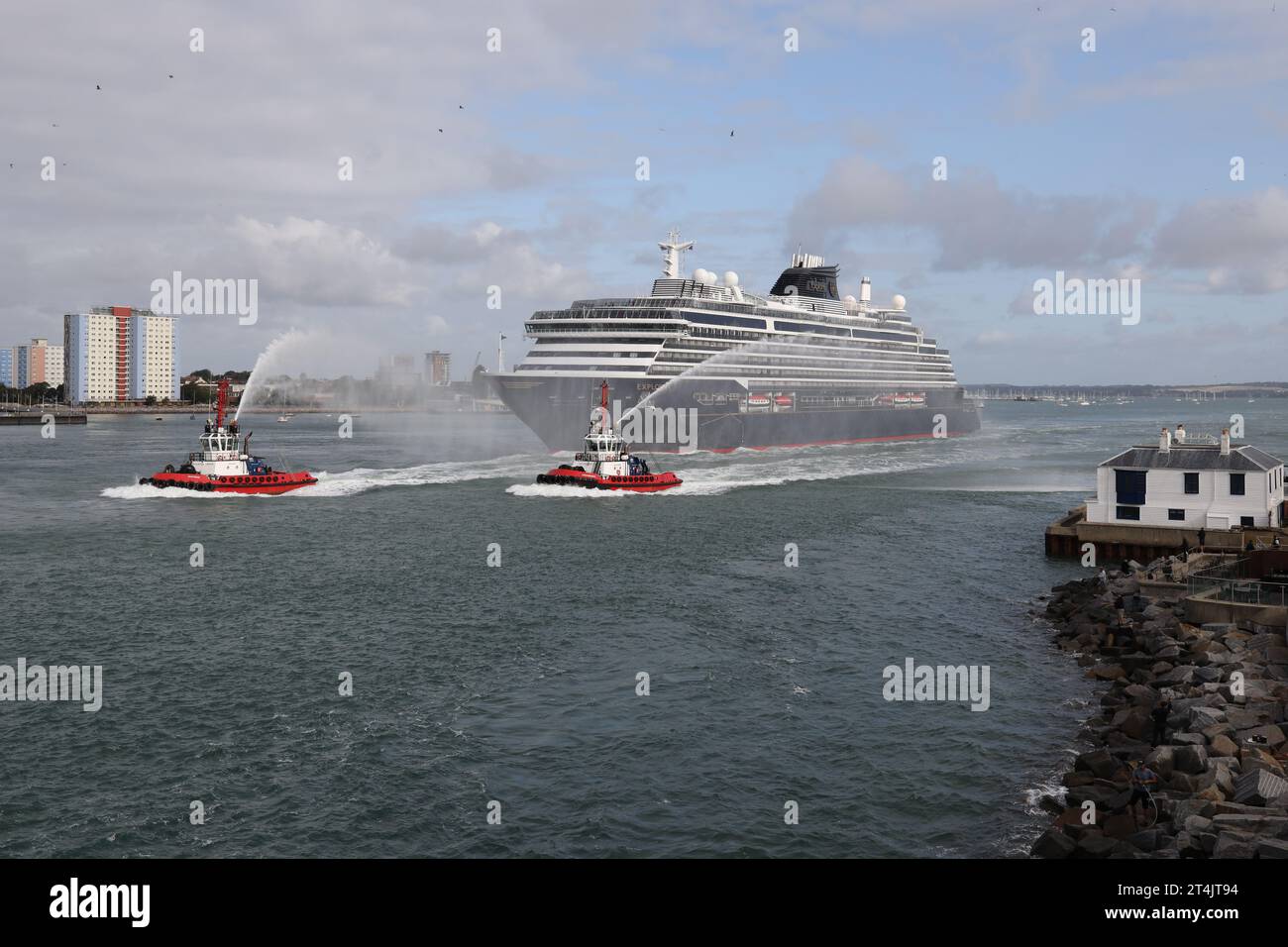 Les remorqueurs fournissent une escorte par jet d'eau alors que le navire à passagers EXPLORA 1 de MSC Cruises quitte la ville et se dirige vers sa prochaine destination Banque D'Images