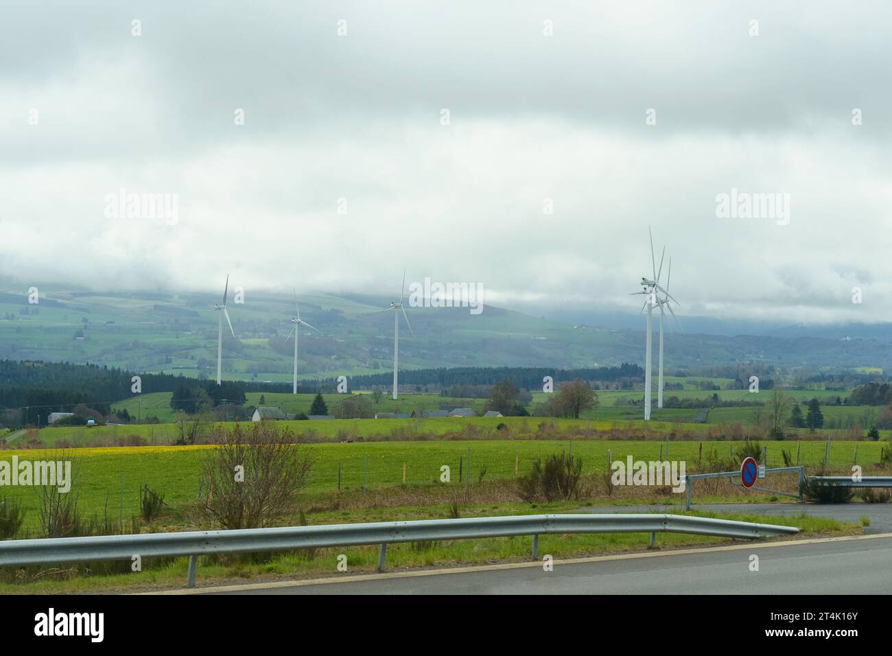 Éoliennes sur le fond du champ, montagnes et nuages. Banque D'Images