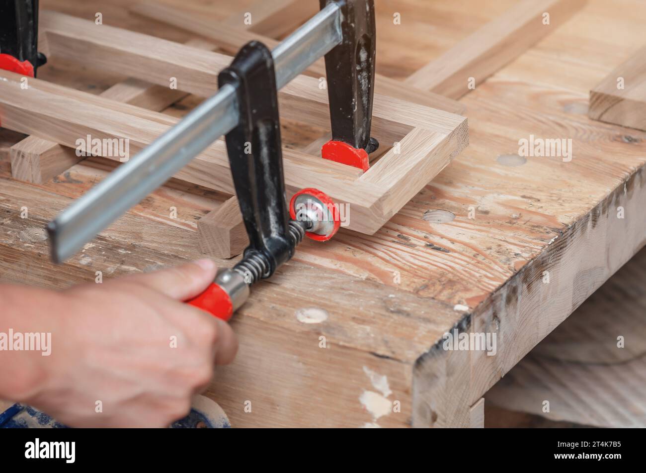 Les pinces de charpentier sont fixées aux planches. Collage de menuiserie dans l'atelier Banque D'Images