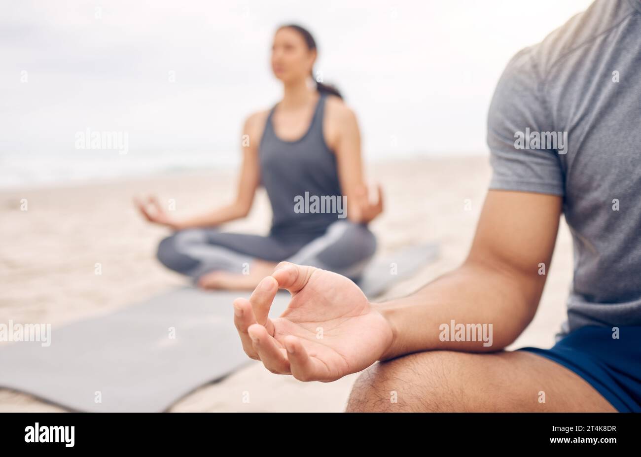 Le yoga vous donnera les compétences nécessaires pour gérer votre stress. Plan rapproché d'un couple méditant tout en pratiquant le yoga ensemble sur la plage. Banque D'Images