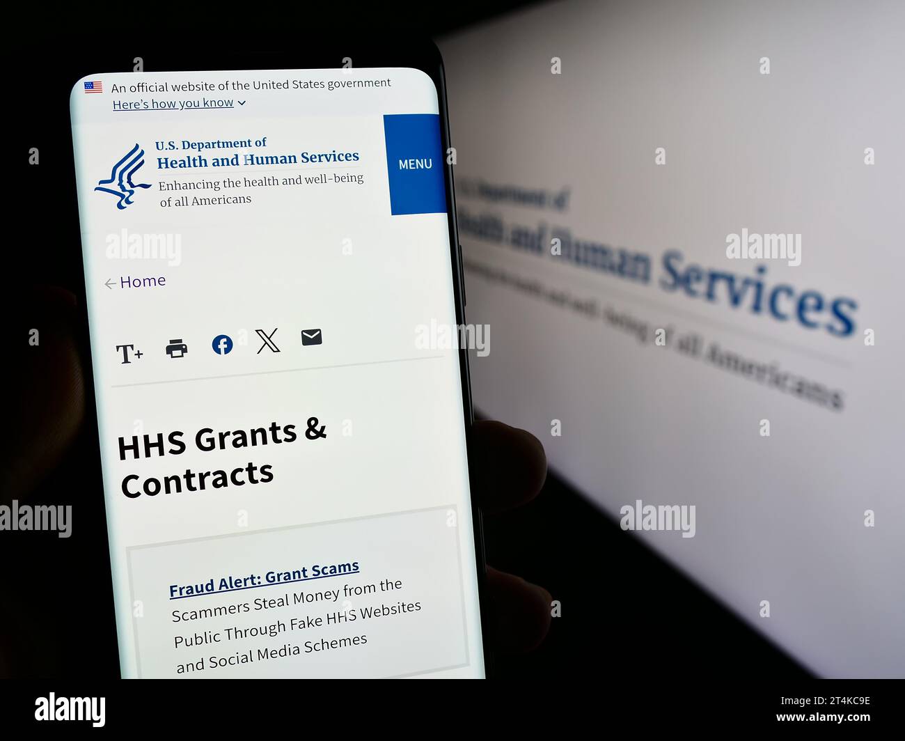 Personne détenant un téléphone portable avec la page Web du ministère américain de la Santé et des Services sociaux (HHS) devant le logo. Concentrez-vous sur le centre de l'écran du téléphone. Banque D'Images