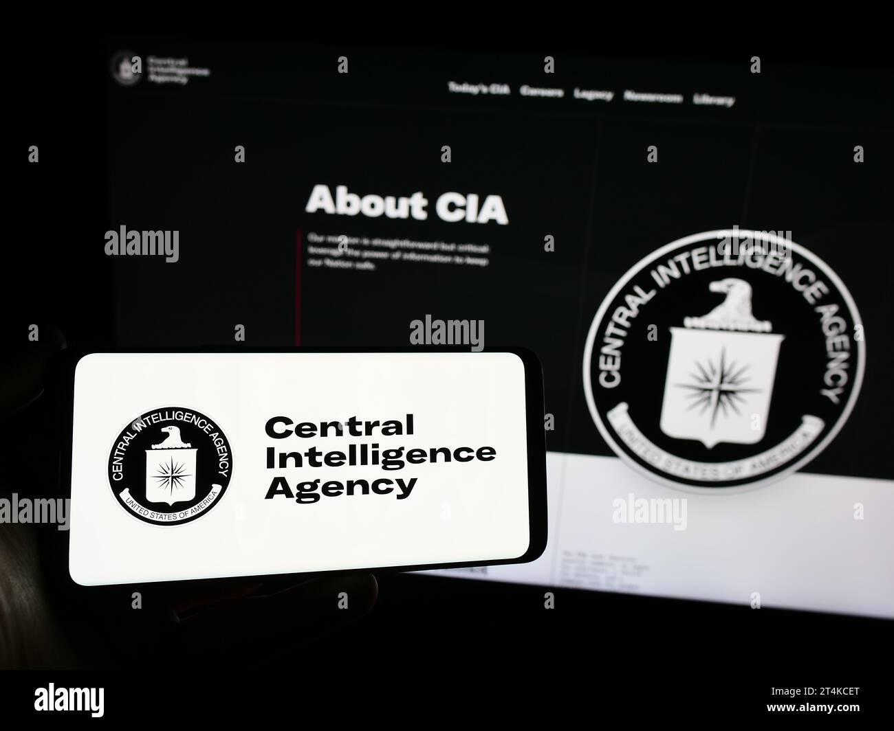 Personne tenant un téléphone portable avec le logo de la CIA (American Central Intelligence Agency) devant la page Web. Concentrez-vous sur l'affichage du téléphone. Banque D'Images