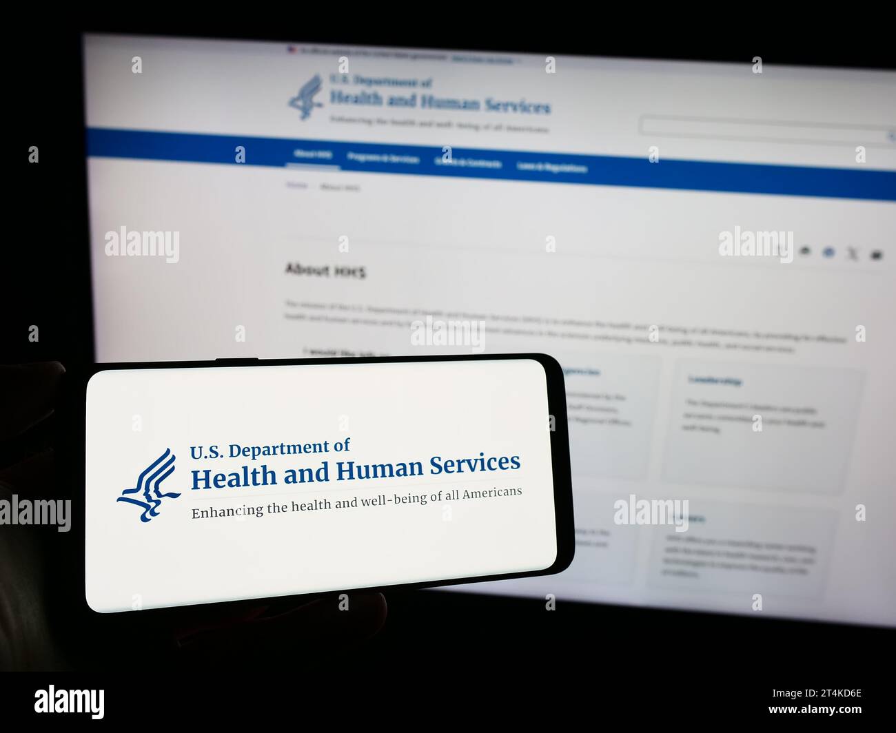 Personne tenant un smartphone avec le logo du ministère américain de la Santé et des Services sociaux (HHS) devant le site Web. Concentrez-vous sur l'affichage du téléphone. Banque D'Images
