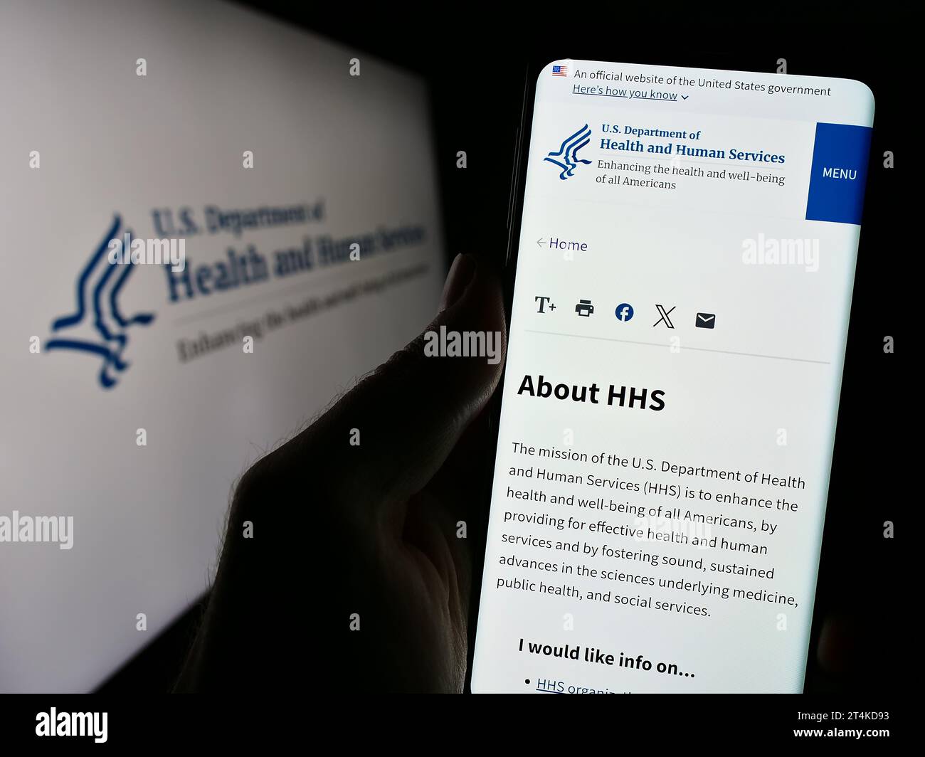 Personne détenant un téléphone portable avec le site Web du ministère américain de la Santé et des Services sociaux (HHS) devant le logo. Concentrez-vous sur le centre de l'écran du téléphone. Banque D'Images