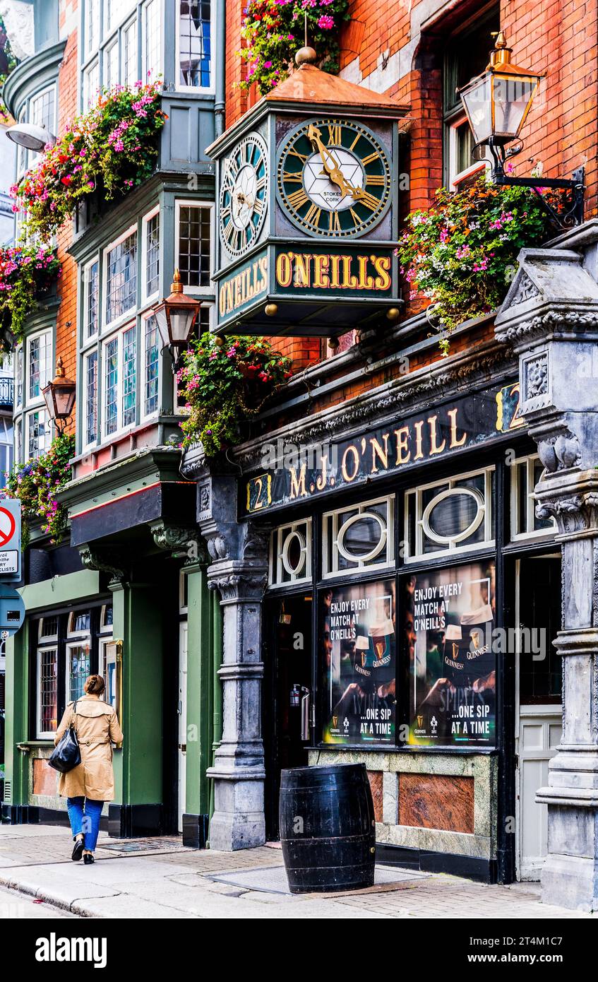 Façade colorée du traditionnel O'Neills Pub à Dublin, avec horloge vintage et paniers suspendus, dans le centre-ville de Dublin, Irlande Banque D'Images