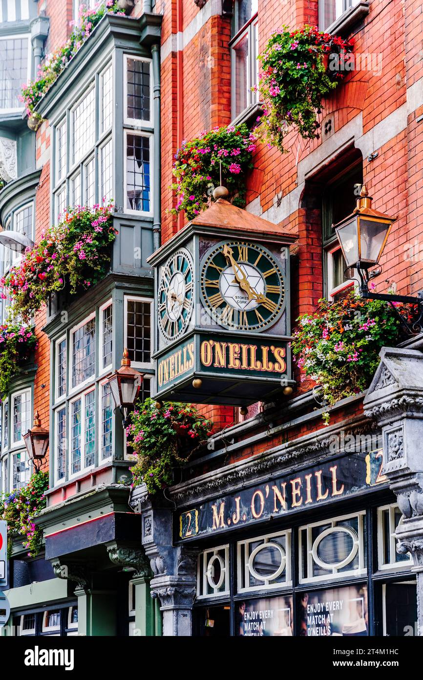 Façade colorée du traditionnel O'Neills Pub à Dublin, avec horloge vintage et paniers suspendus, dans le centre-ville de Dublin, Irlande Banque D'Images