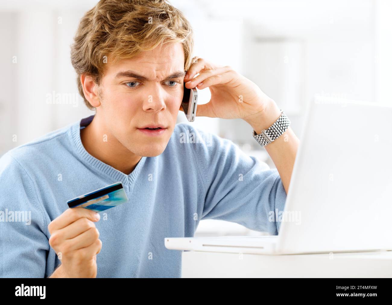 Le système de paiement en ligne est cassé. un jeune homme faisant un appel téléphonique en colère tout en effectuant des paiements en ligne. Banque D'Images