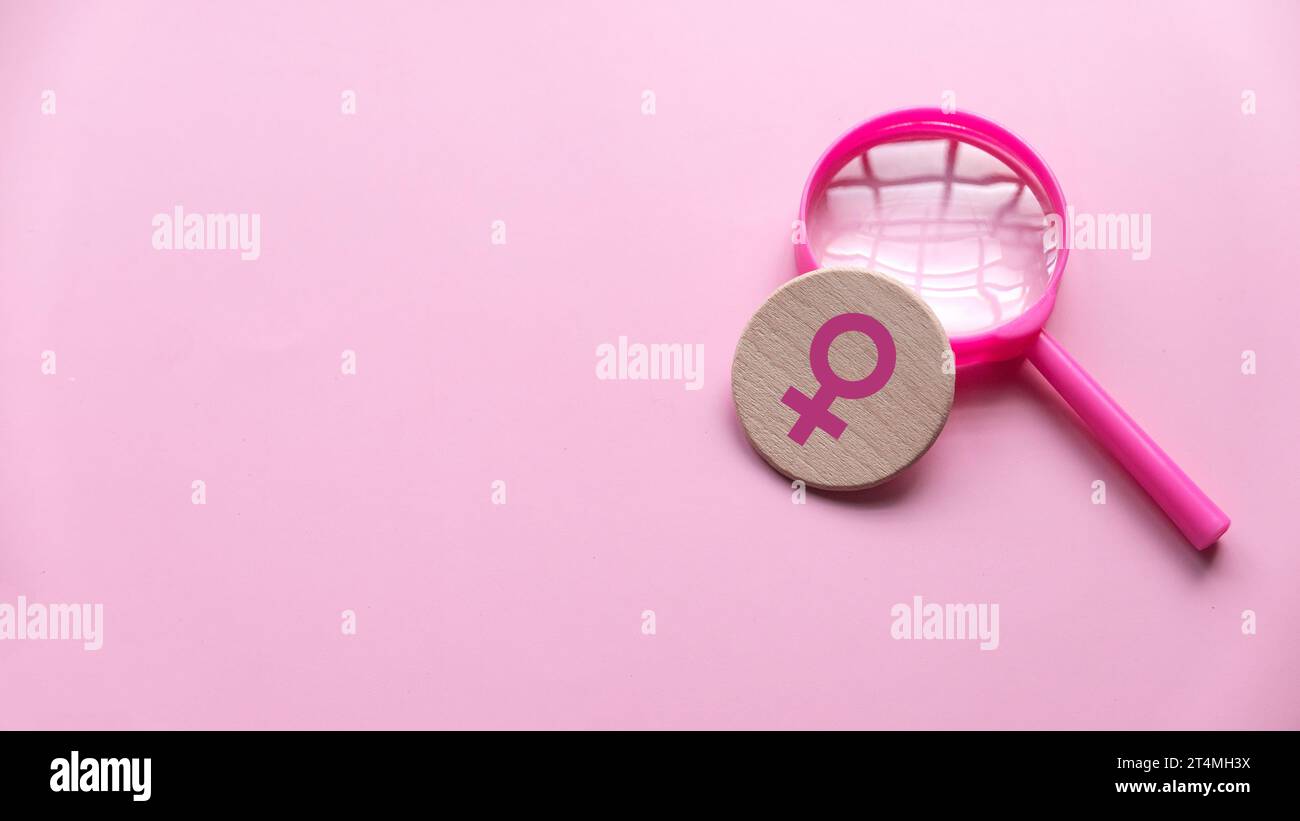 Questions et réponses sur le concept des femmes. Symbole des femmes sur une loupe sur fond rose avec espace de copie. Banque D'Images