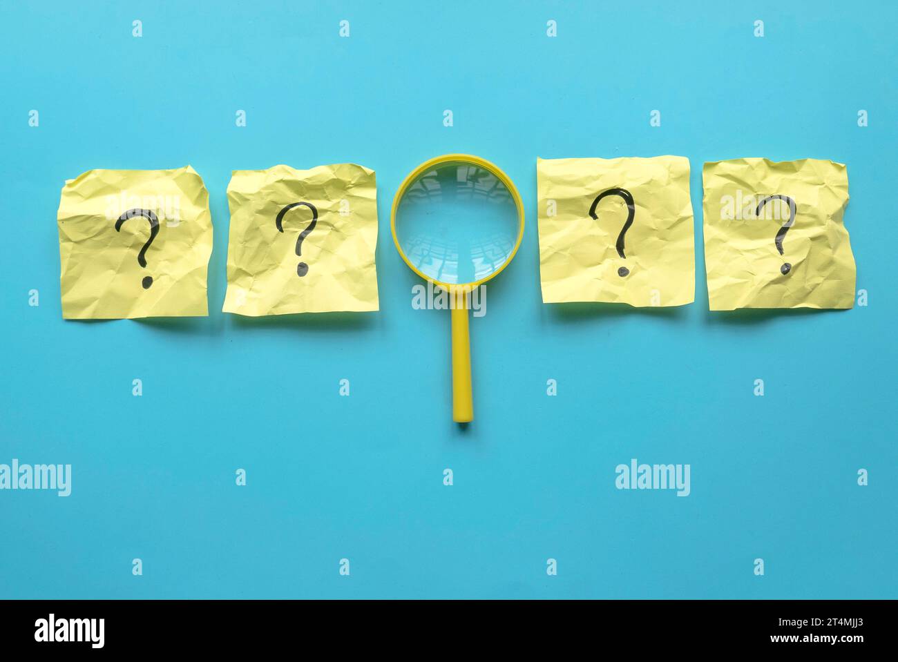 QnA ou concept de questions et réponses. Loupe jaune avec un symbole de question sur un mémo-note sur un fond bleu. Banque D'Images